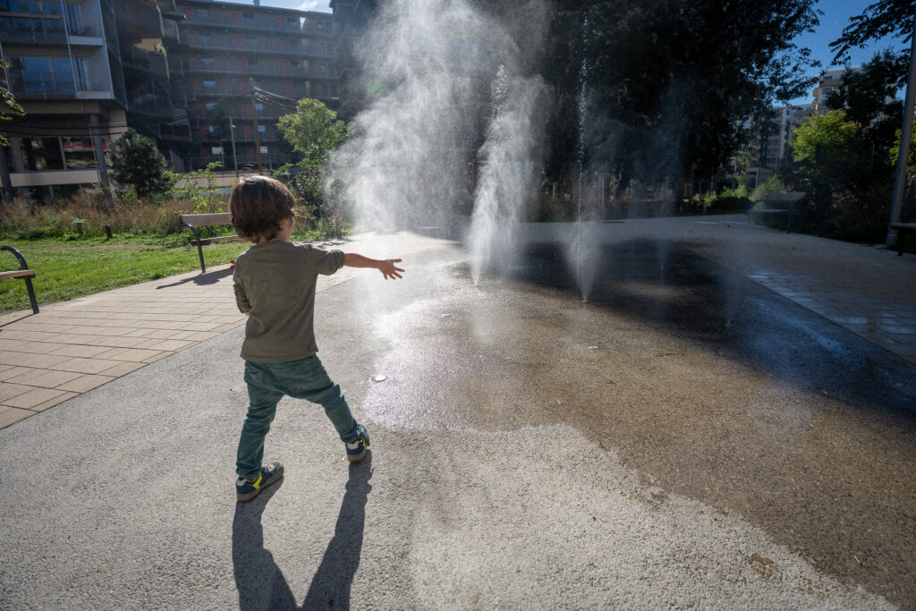 Child playing near ground water jets