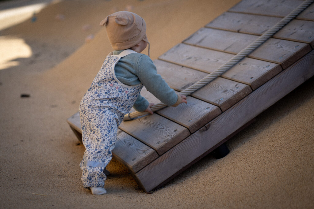 Child climbing up a wooden ramp