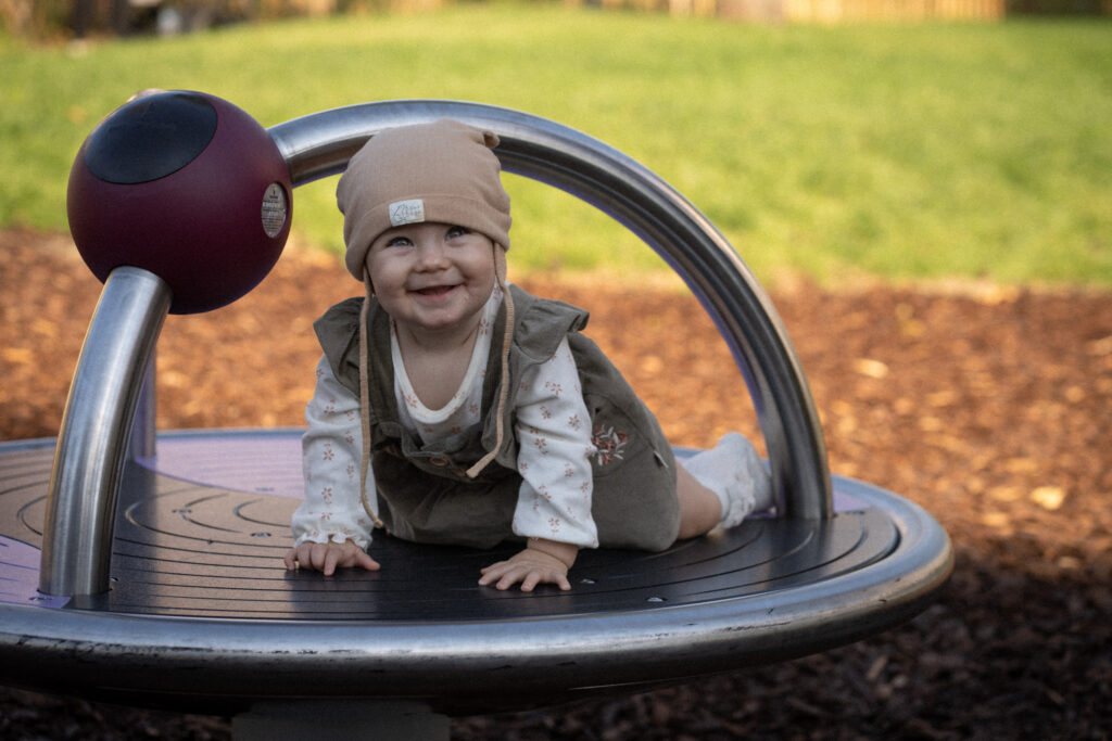 Toddler playing on the low-level roundabout carousel
